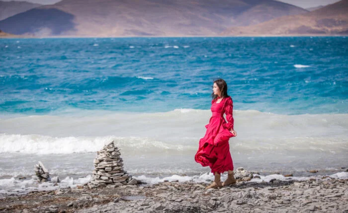 Beautiful girl near tibetan lake